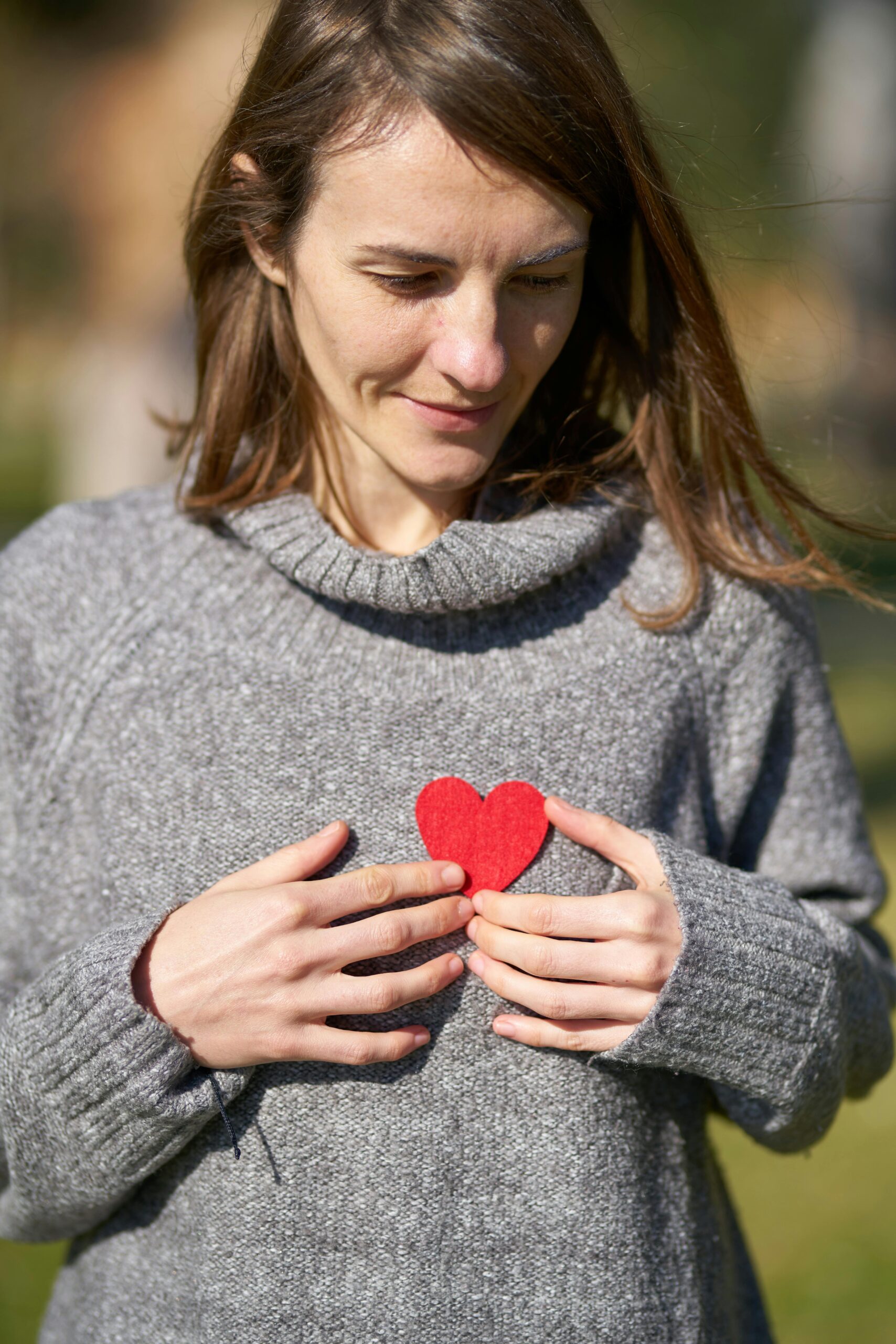 woman after Psychiatric Rehabilitation with a paper heart on chest