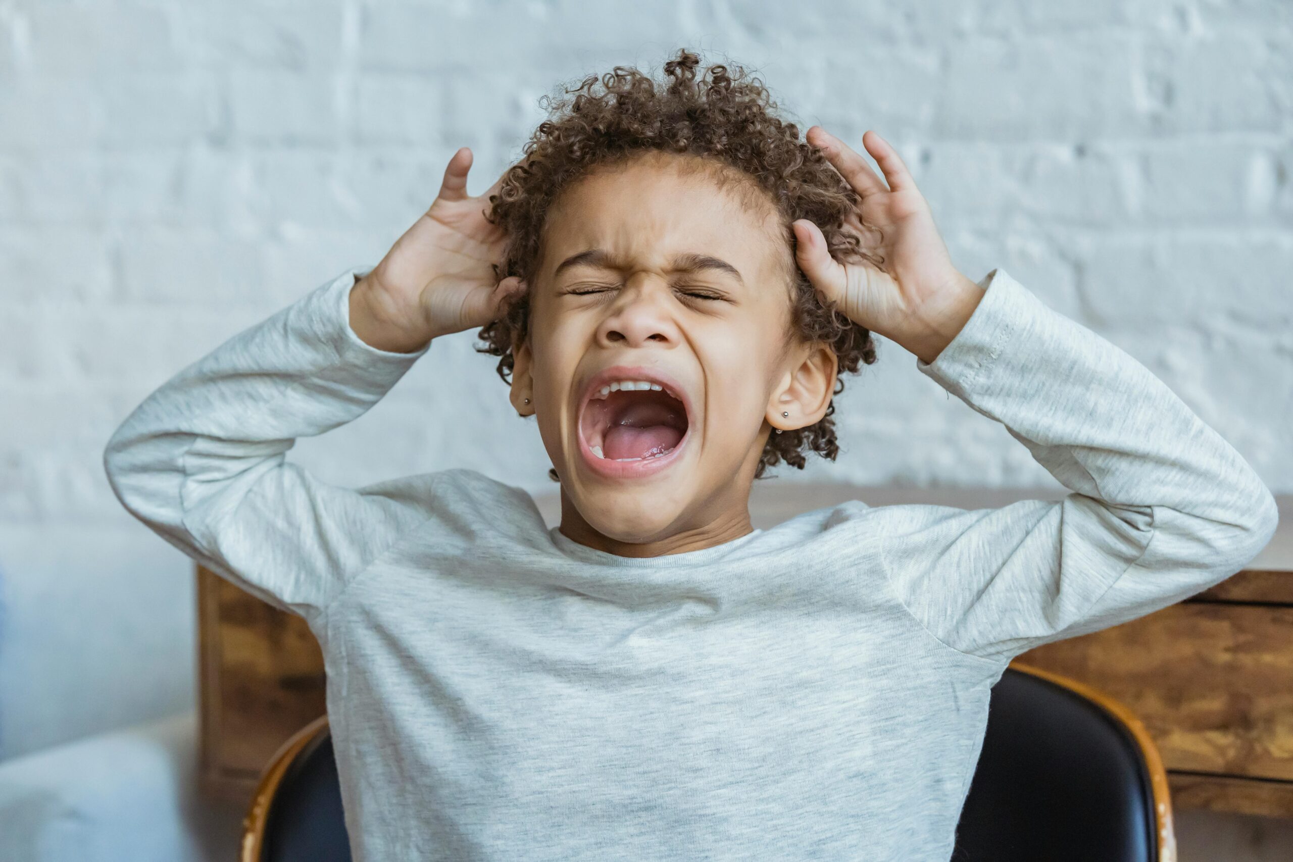 child with signs of a behavioral disorder screaming and having a tanrum